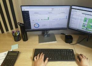 2 écrans d'ordinateur avec un clavier et un souris et des stats sur les écrans